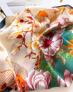 Dettaglio foulard in seta con motivi di magnolia, foglie di ginkgo e bordo blu scuro