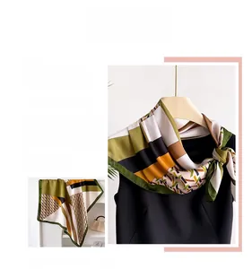 Detail of elegant houndstooth silk-like scarf with green and gold geometric patterns