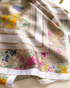 Gros plan du foulard en soie montrant des imprimés floraux de lys et de petits insectes
