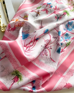 Détail macro d'un foulard en satin aux rayures roses avec motifs de fleurs et libellules