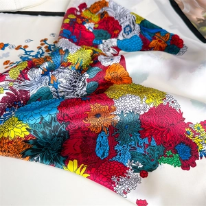 Close-up of floral print ivory silk scarf featuring colorful chrysanthemum patterns