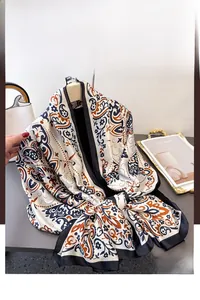 Detail of bohemian floral print satin shawl with vintage patterns in cream and orange