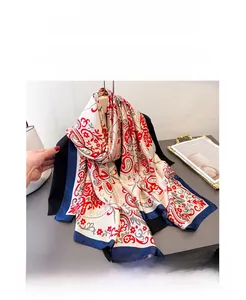 Detail of silk-like scarf with red paisley patterns and navy blue contrast borders