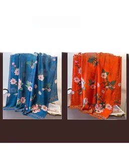 Detailed view of floral print silk scarf in navy blue and bright orange silk fabric