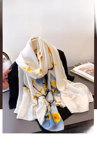 Détails de l'écharpe en soie blanche avec motifs floraux jaunes et branches à l'encre