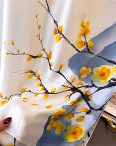 Détail du foulard en soie montrant l'imprimé fleuri et la texture du tissu