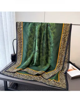 Detail of silk satin scarf showing green floral center and leopard print borders