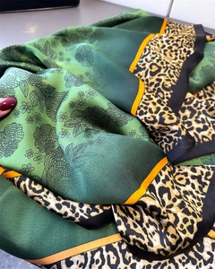 Detail of satin silk scarf featuring green floral prints and leopard pattern borders