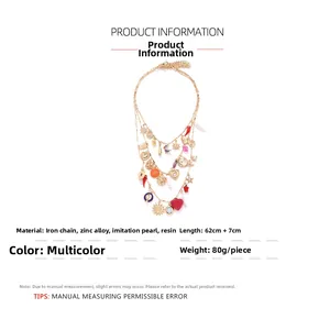 Detailed view of multilayer gold necklace with heart, pearl, and sun charms