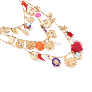 Bohemian gold layered necklace with heart chili and shell charms on white background