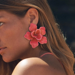 Gros plan détaillé de la grande boucle d'oreille fleur en émail rose sur un mannequin chic