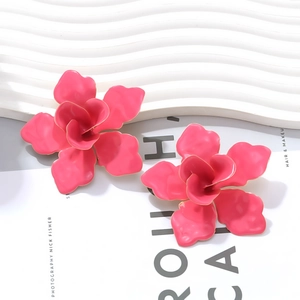 Détail des boucles d'oreilles fleur 3D rose vif avec bordure dorée et émail luxueux