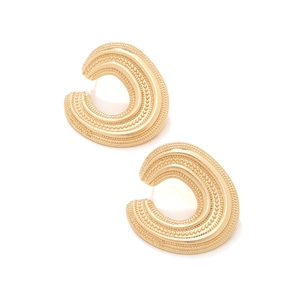 Detail of vintage C-shaped gold earrings with hollow spiral design and beaded texture