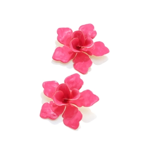 Détail de boucles d'oreilles fleurs en émail rose en 3D avec des bords dorés raffinés