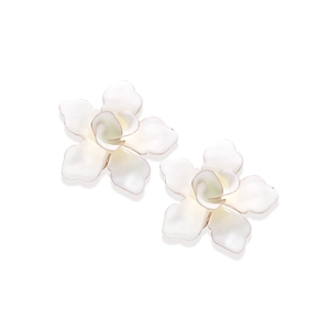 Vue macro détaillée de boucles d'oreilles fleur en émail ivoire avec bords dorés sur blanc