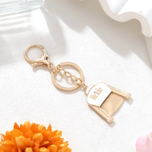 Golden bridal wedding dress keychain with white enamel Bride text and small pearls