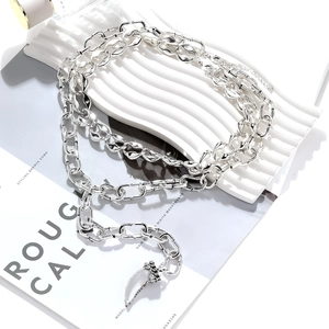 Detail of silver layered necklace with antique carved metal horn pendant on art magazine