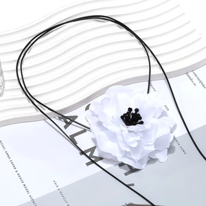 Macro detail of chic black and white layered fabric flower pendant with crystal beads