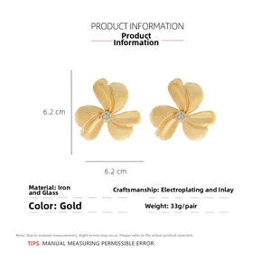 Macro detail of gold floral drop earrings with clear glass stones and size measurements