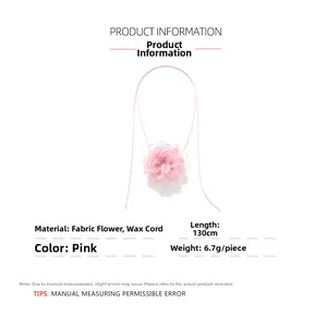 Gros plan sur la fleur en mousseline rose superposée sur un collier en corde réglable