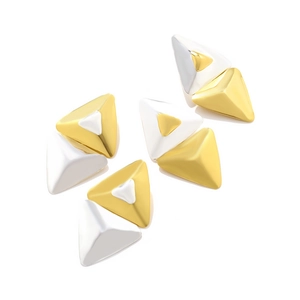 Detailed macro view of geometric 3D triangle earrings in polished gold and silver metal finishes