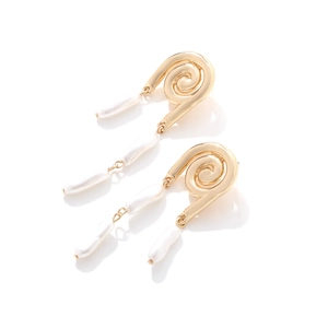 Detail of spiral gold-toned earrings with baroque pearls on a clean white background