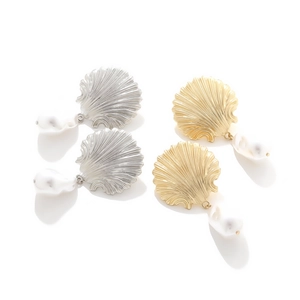 Detail of shell-shaped earrings in gold and silver with baroque pearls on white background