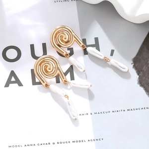 Elegant gold spiral drop earrings with baroque white pearls on a minimalist background