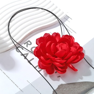 Exaggerated handmade red fabric flower choker necklace on a minimalist black cord