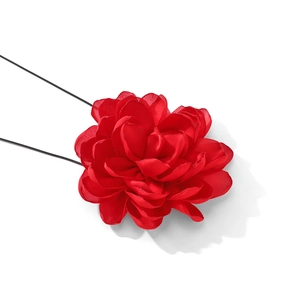 Close-up of a large red fabric flower necklace with elegant satin petals and pins