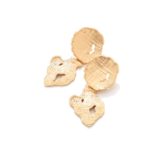 Dettaglio della trama martellata degli orecchini vintage in oro con design artistico creativo