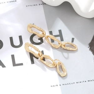 Vintage gold layered geometric earrings with hammered texture in a chic aesthetic layout