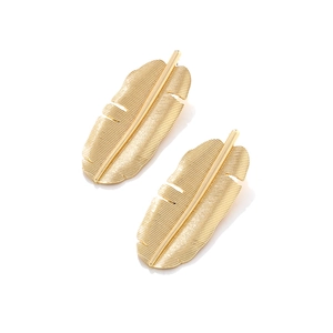 Macro shot of gold banana leaf earrings with a brushed metal texture and retro design