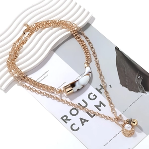 Bohemian gold layered necklace with marble horn pendant and embossed coin charms