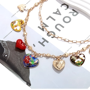 Détail du collier doré avec plusieurs pendentifs en émail coloré et motifs d'oiseaux