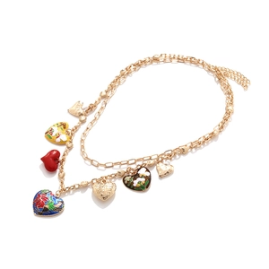 Détail du collier chaîne dorée double couche avec breloques cœur et oiseau en émail