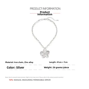 Close-up of silver five-petal flower pendant necklace with textured petals and thick link chain