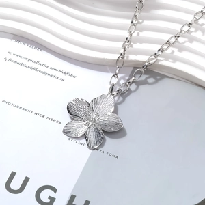 Minimalist silver flower pendant necklace with brushed metal texture and chunky chain links