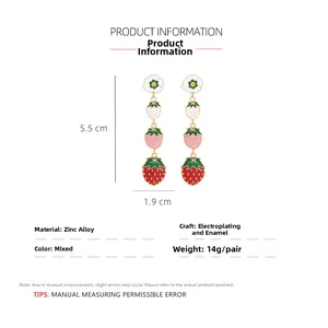 Détail des boucles d'oreilles fraise montrant 5,5 cm de long et design floral en alliage