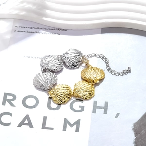 Detail of two-tone alloy shell necklace showing gold and silver textures with lobster clasp