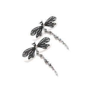 Detailed macro view of vintage silver dragonfly earrings with white pearls and crystals