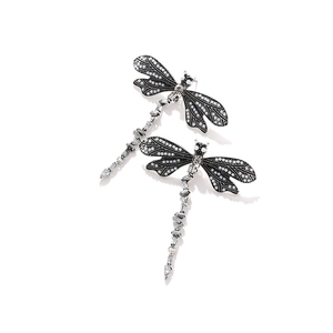 Macro view of dragonfly earrings with black wings, imitation pearls and clear rhinestones