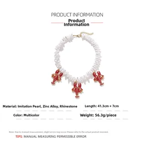 Detail of baroque pearl necklace featuring red enamel lobster charms with rhinestones