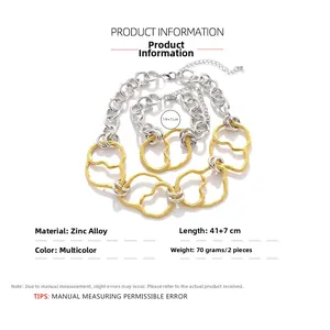 Détail du collier et bracelet à grosse chaîne argentée et maillon doré irrégulier