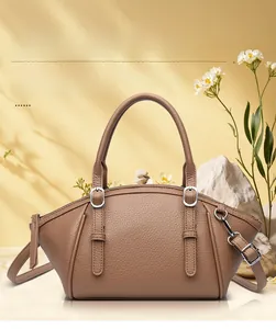 Détail d'un sac à main en cuir litchi marron foncé avec boucles en métal et design à ailes