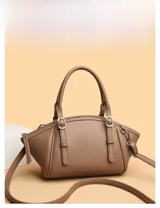 Détail du sac à main en cuir grainé marron clair avec boucles argentées et bandoulière