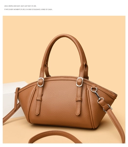 Détail d'un sac à main en cuir grainé marron avec boucles argentées et bandoulière fine