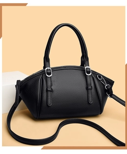 Détail du sac à main en cuir grainé noir avec boucles argentées et doubles poignées