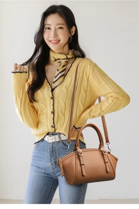 Sac cabas en cuir marron avec doubles poignées et bandoulière porté par un mannequin