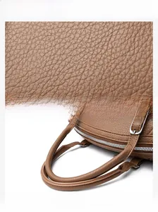 Vue détaillée du cuir marron grainé et des coutures précises sur le sac à main
